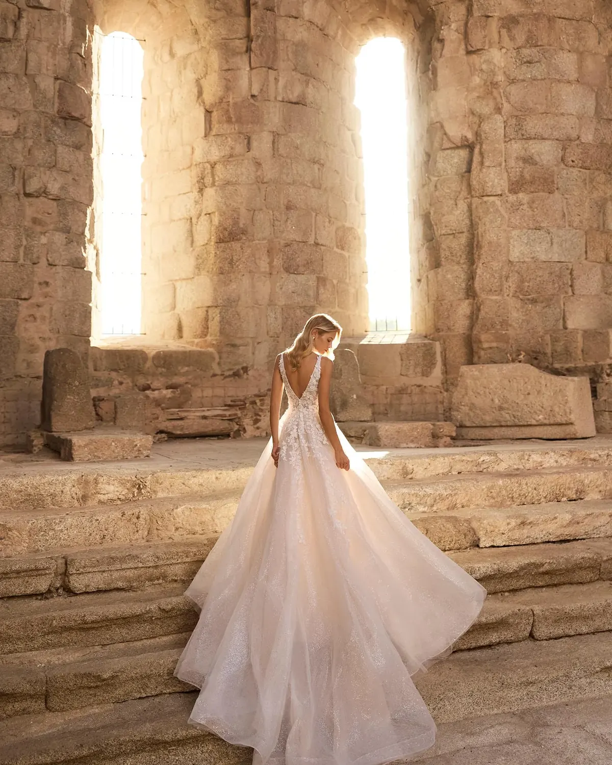 Adriana Alier Perseo 2N29 wedding dress — full-length back editorial with glitter tulle skirt in motion